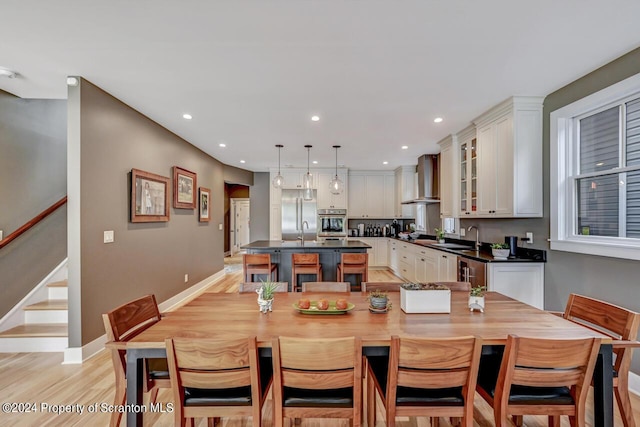 dining space with light hardwood / wood-style floors and sink