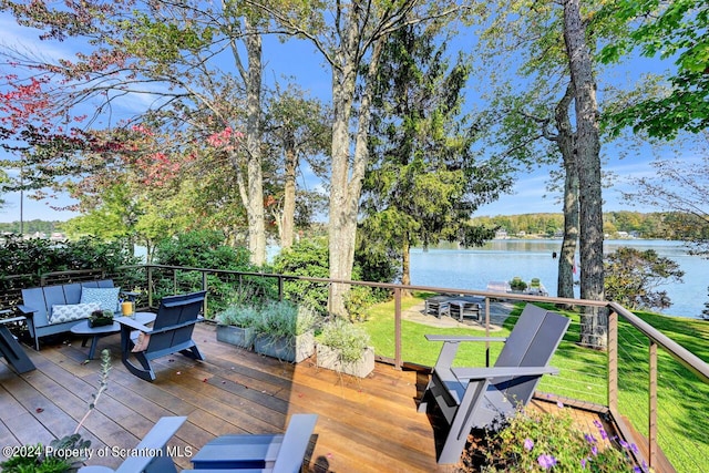 wooden deck with outdoor lounge area, a yard, and a water view