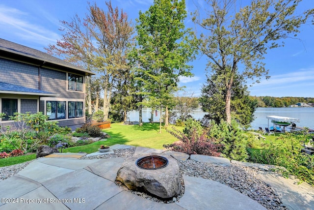 view of patio with a water view and a fire pit