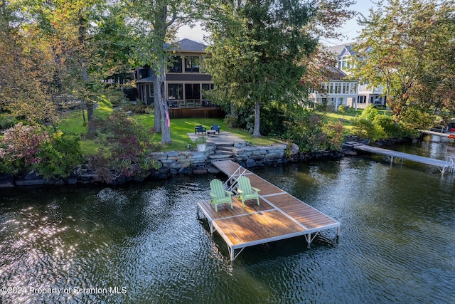 dock area featuring a lawn and a water view