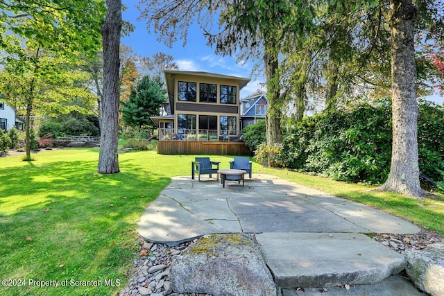 back of property with a lawn and a patio area