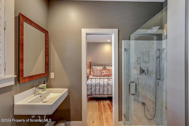 bathroom featuring sink, wood-type flooring, and a shower with shower door