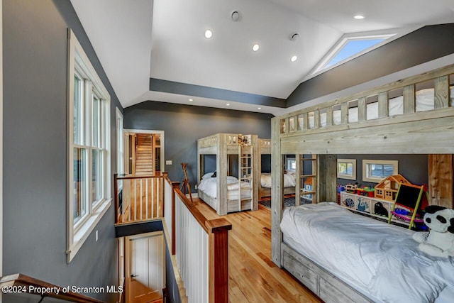 bedroom featuring light hardwood / wood-style floors and high vaulted ceiling