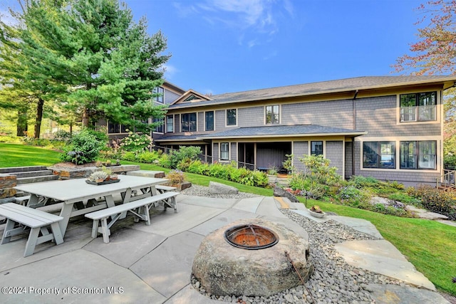 back of property featuring a patio area and a fire pit