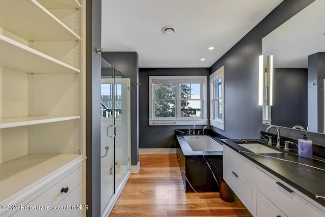 bathroom with shower with separate bathtub, vanity, and hardwood / wood-style flooring