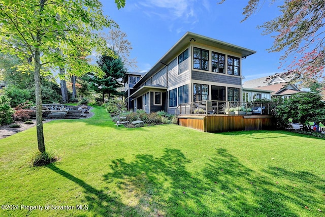 rear view of property with a yard and a sunroom