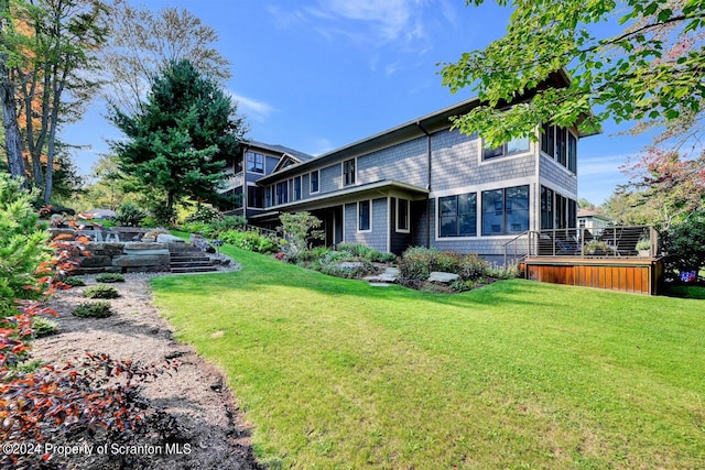 rear view of property featuring a sunroom and a yard