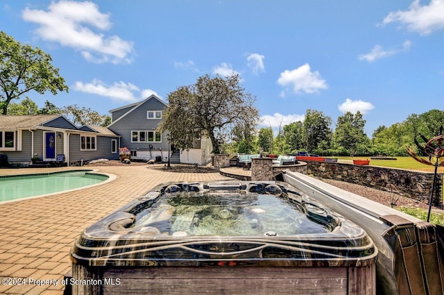 view of swimming pool with a patio and a hot tub