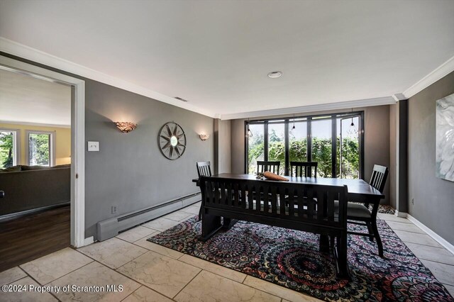 dining space featuring crown molding, baseboard heating, and a healthy amount of sunlight