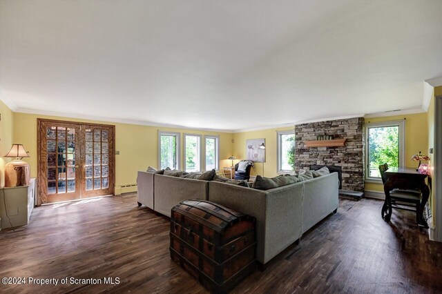 living room with dark hardwood / wood-style floors, crown molding, baseboard heating, and a wealth of natural light