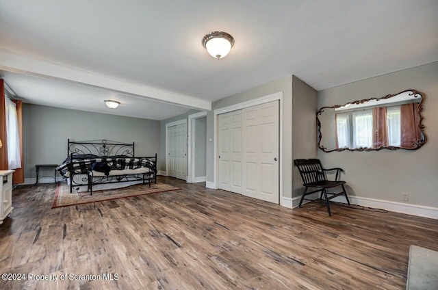 bedroom featuring beam ceiling and wood-type flooring