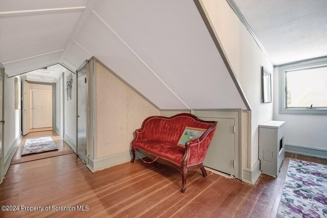 living area featuring hardwood / wood-style flooring and vaulted ceiling