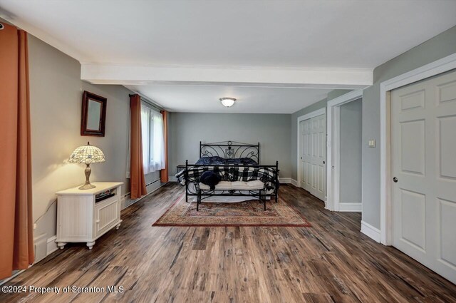 bedroom with beam ceiling, dark wood-type flooring, and a baseboard radiator