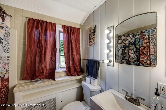 bathroom featuring a shower with curtain, vanity, toilet, and vaulted ceiling