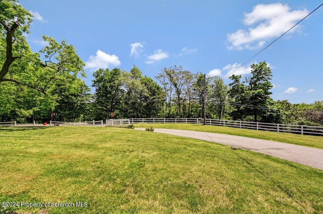 view of property's community featuring a yard and a rural view