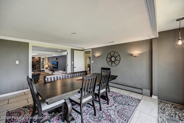 dining room with ornamental molding and a baseboard heating unit