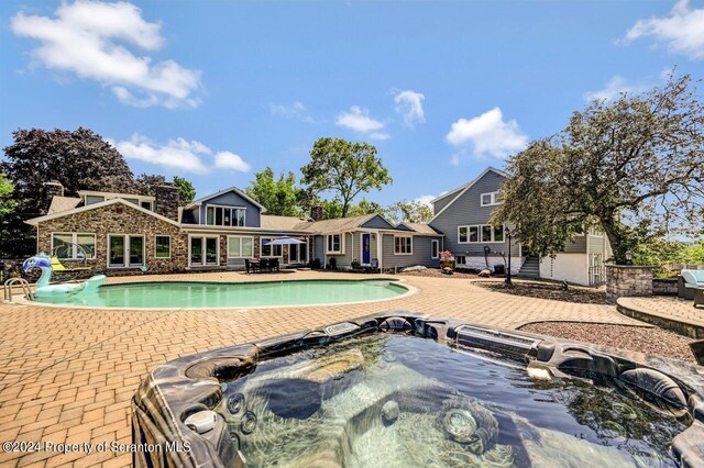 view of swimming pool with a patio area and a hot tub