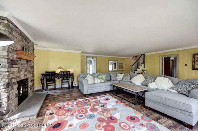 living room with crown molding, a fireplace, and dark wood-type flooring