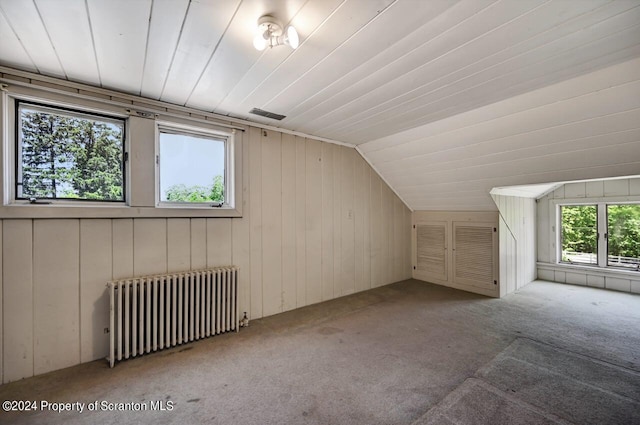 bonus room with light carpet, radiator heating unit, and lofted ceiling