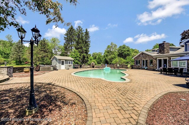 view of swimming pool with a patio area and an outdoor structure