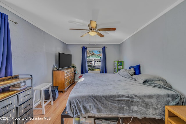 bedroom featuring ceiling fan, crown molding, and light hardwood / wood-style flooring