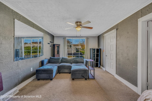 carpeted living room with ceiling fan and ornamental molding