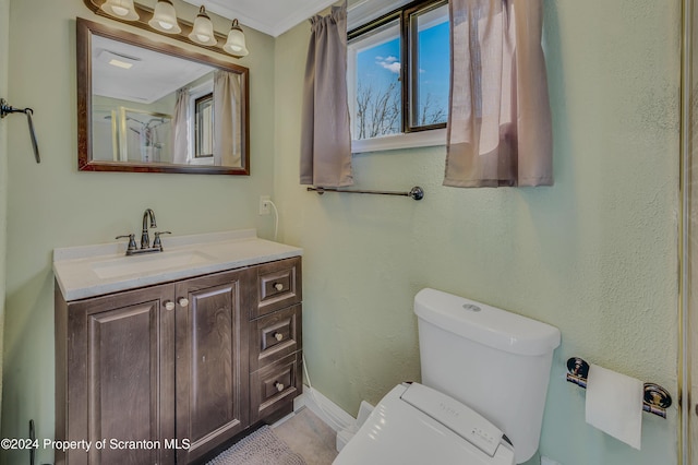 bathroom featuring vanity, toilet, and ornamental molding