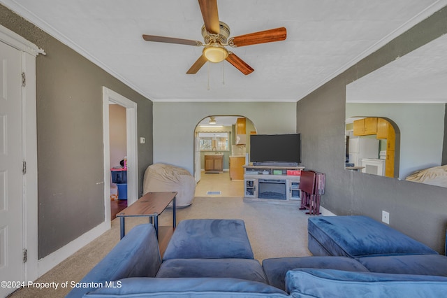 living room with carpet, crown molding, and ceiling fan