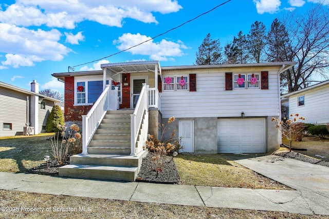 view of front of house with stairs, concrete driveway, and a garage