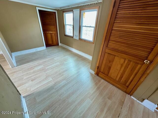 interior space with light wood-type flooring and ornamental molding