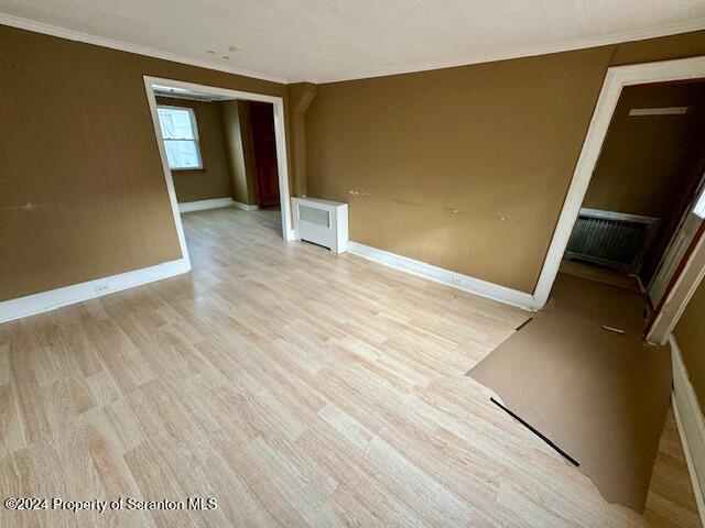 unfurnished room featuring light hardwood / wood-style floors and ornamental molding