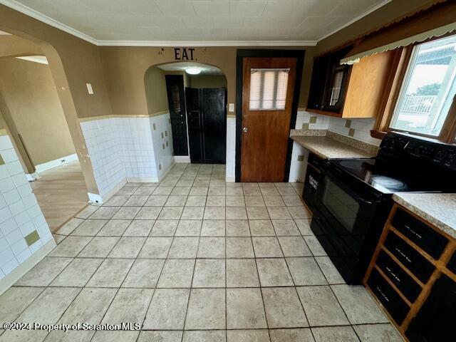 kitchen with black range with electric stovetop, crown molding, and light tile patterned floors