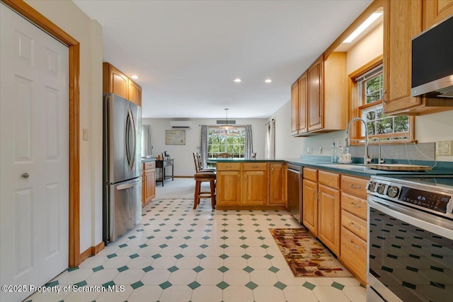 86 Paupack Point Rd, Hawley, PA 18428 - kitchen with appliances with stainless steel finishes, a peninsula, a wall mounted air conditioner, recessed lighting, and light floors