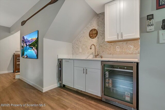 86 Paupack Point Rd, Hawley, PA 18428 - indoor wet bar with beverage cooler, wood finished floors, backsplash, baseboards, and lofted ceiling