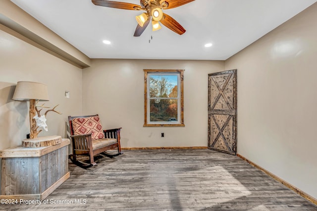 sitting room featuring hardwood / wood-style floors and ceiling fan