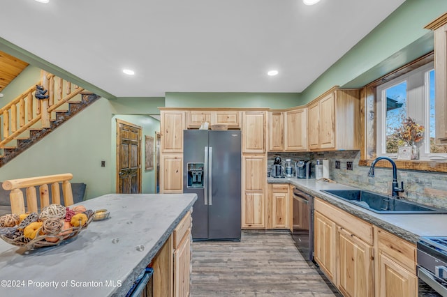 kitchen with sink, stainless steel appliances, light brown cabinets, and light hardwood / wood-style floors