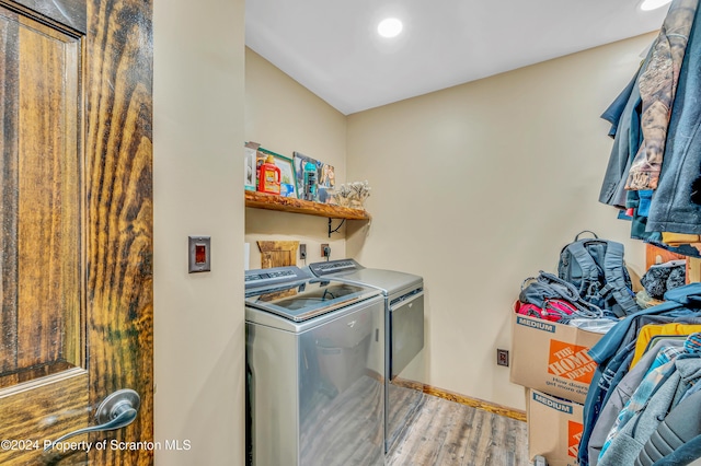 washroom with washer and clothes dryer and light hardwood / wood-style flooring