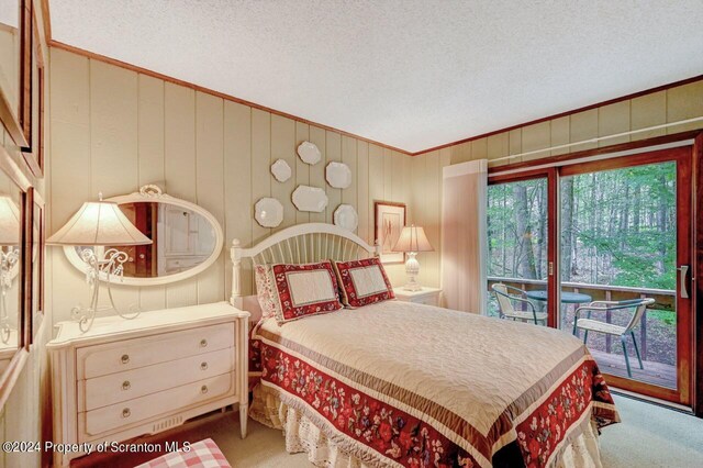 bedroom featuring access to exterior, carpet floors, and a textured ceiling