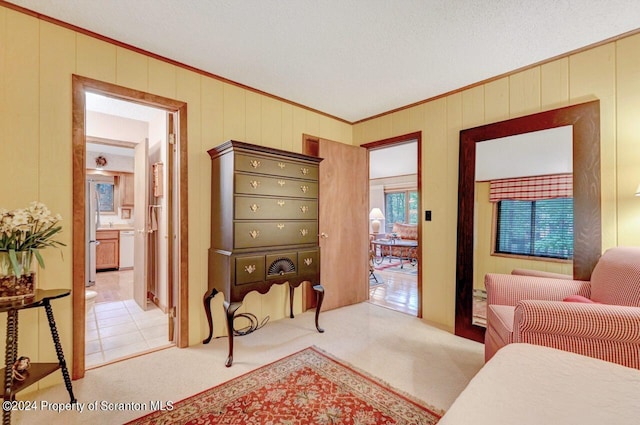 bedroom featuring light carpet, a textured ceiling, stainless steel refrigerator, and crown molding