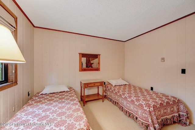 carpeted bedroom with a textured ceiling, ornamental molding, and wood walls