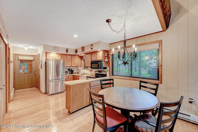 kitchen featuring appliances with stainless steel finishes, a textured ceiling, an inviting chandelier, light hardwood / wood-style floors, and hanging light fixtures