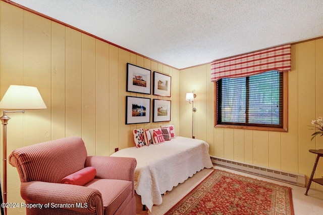 bedroom featuring baseboard heating, wooden walls, and a textured ceiling