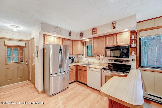 kitchen featuring a textured ceiling, stainless steel appliances, a baseboard heating unit, sink, and light hardwood / wood-style flooring