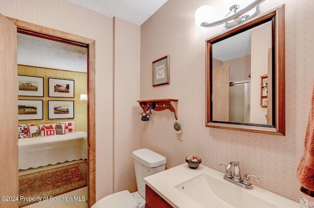 bathroom featuring vanity, toilet, and a textured ceiling