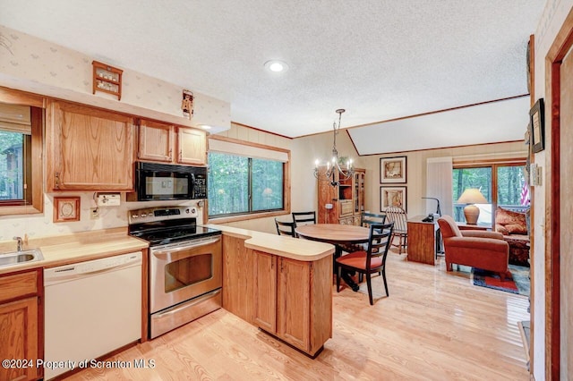 kitchen featuring an inviting chandelier, white dishwasher, hanging light fixtures, stainless steel electric range oven, and kitchen peninsula