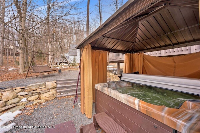 exterior space featuring a hot tub and a gazebo