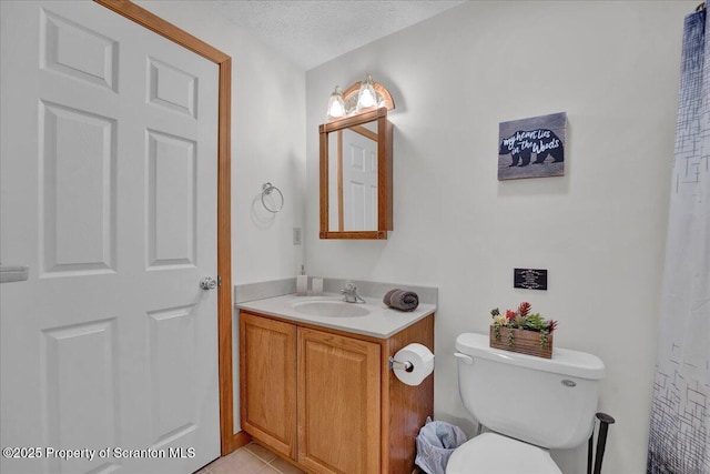 full bathroom with toilet, tile patterned flooring, a textured ceiling, and vanity