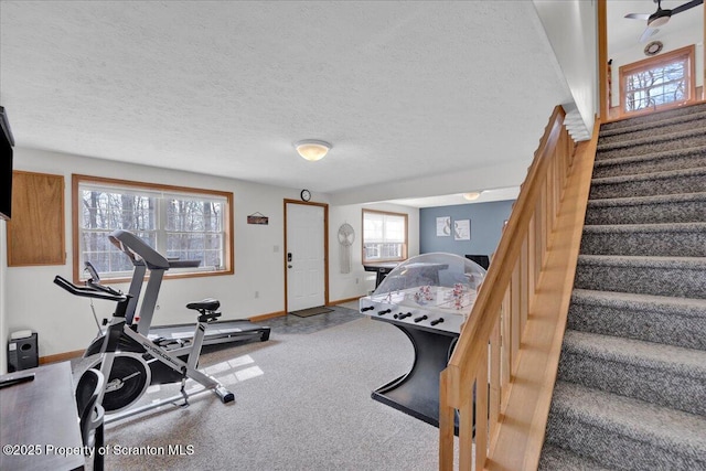 exercise area with a textured ceiling and baseboards