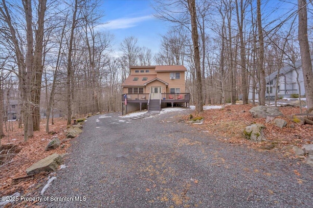 rustic home featuring driveway and a wooden deck