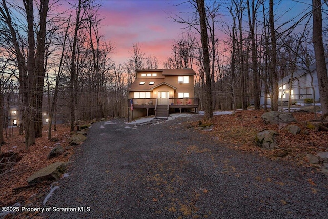 rustic home with driveway and a wooden deck